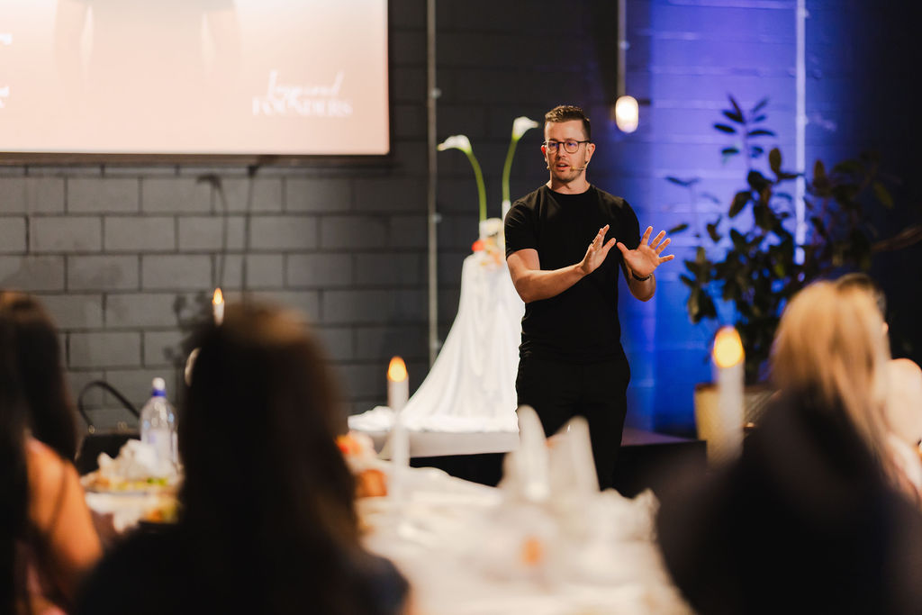 A speaker in black talking to Inspired Founders guests