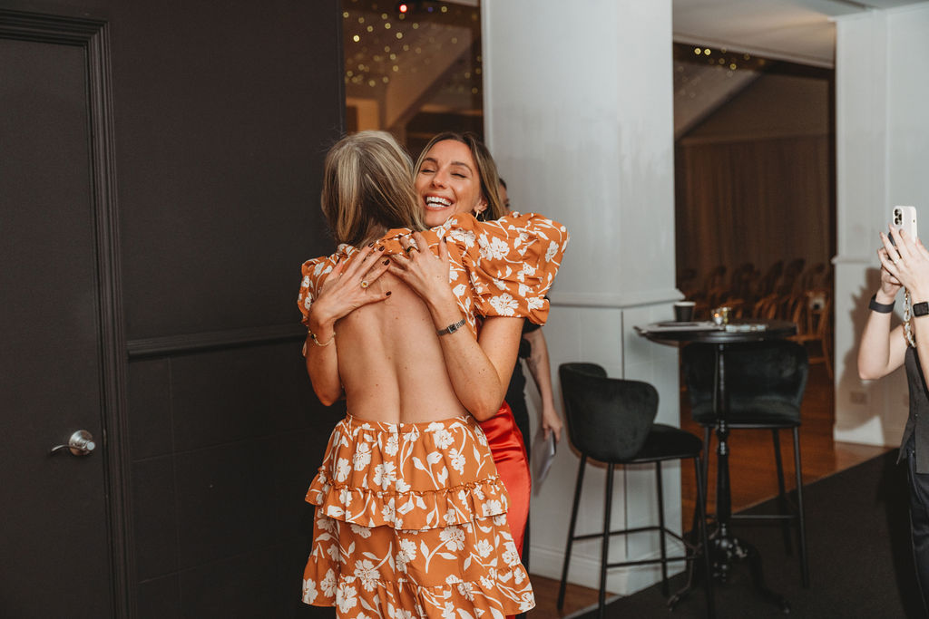 Two founders embracing in a warm hello at an Inspired Founders event
